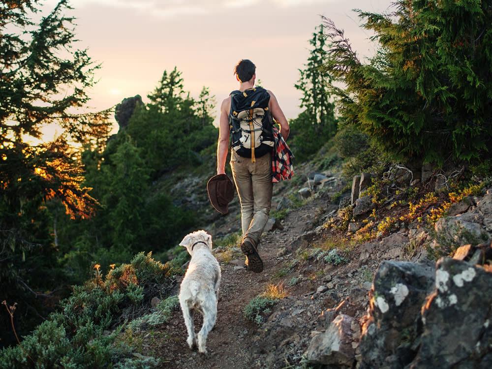 man and dog being active on hike