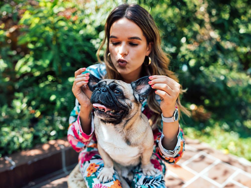 Woman holding pug in her lap